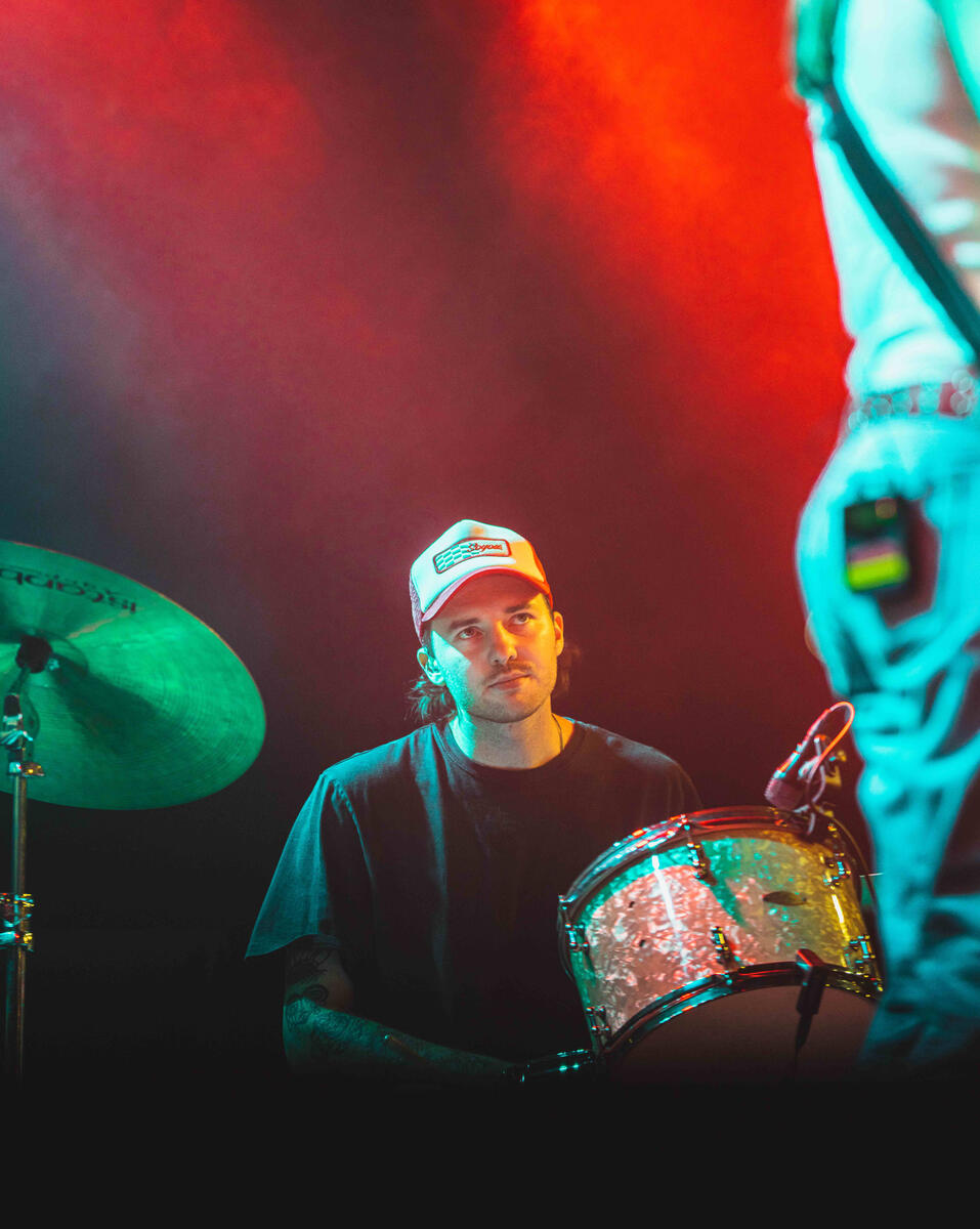 Coloured photo of drummer looking at lead vocalist. Band is "Loviet"