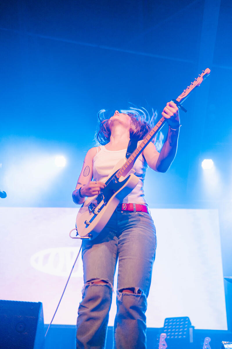 Coloured image of band member flicking hair. Band is "Loviet"