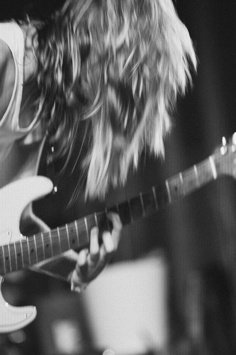 Black and white close up image of guitarist with fingers on 8th fret. Band is "Loviet"