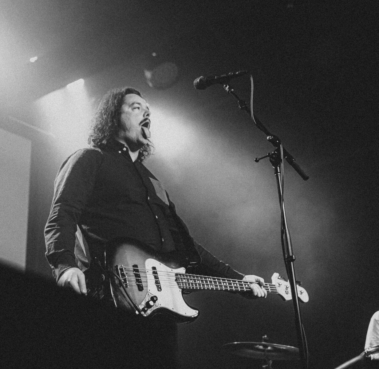 Black and white photo of bassist with tongue out. Band is &quot;Born Ruffians&quot;