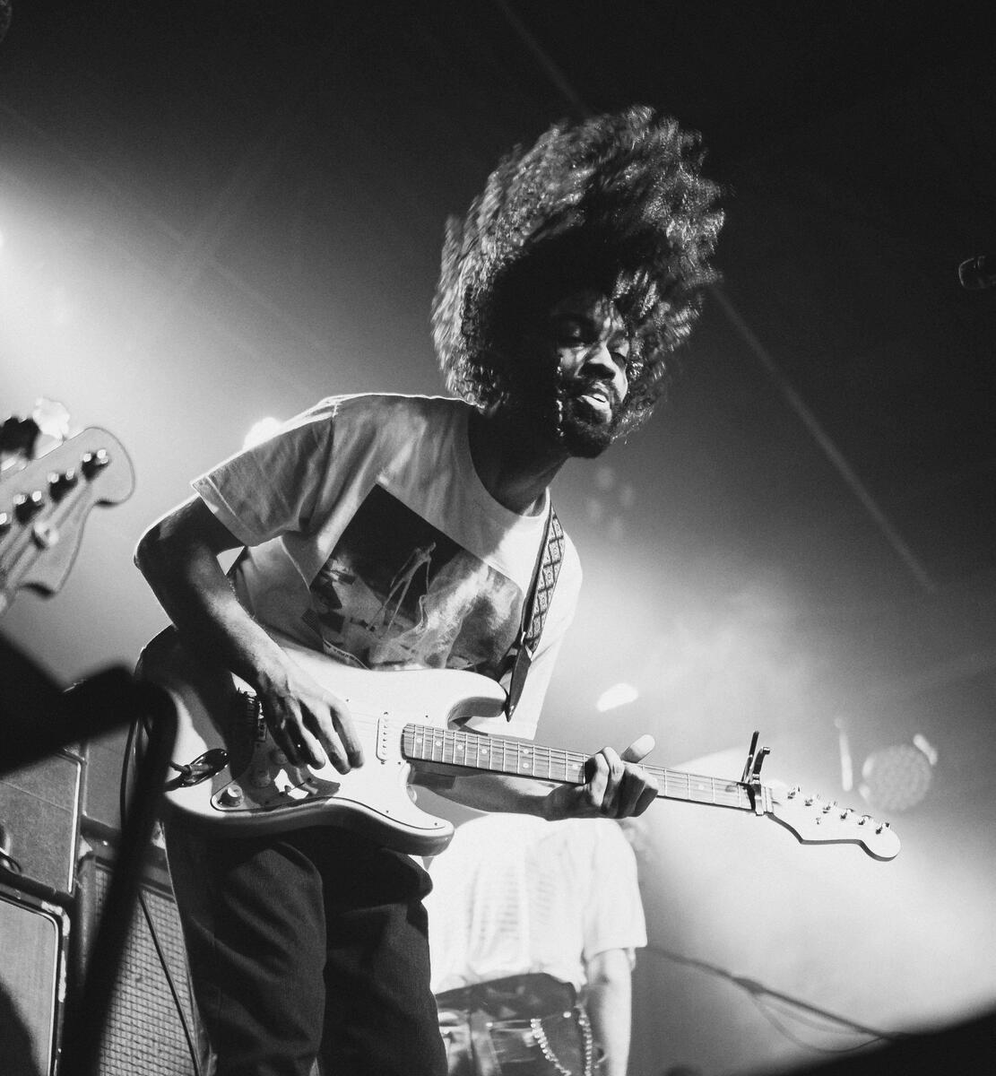 Black and white photo of band member flicking their hair on stage. Band is "Chastity"