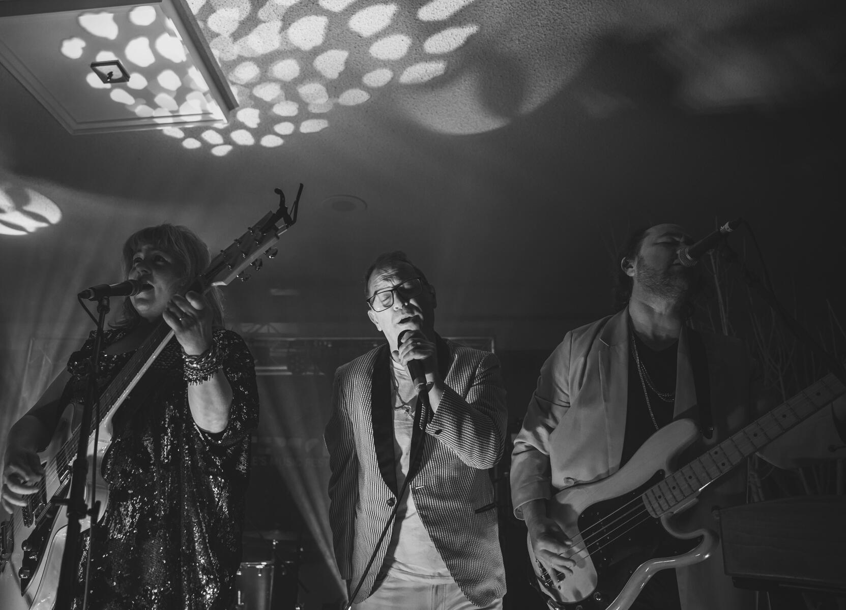 Black and white image of men and women playing beside each other on stage. Band is &quot;Stars&quot;