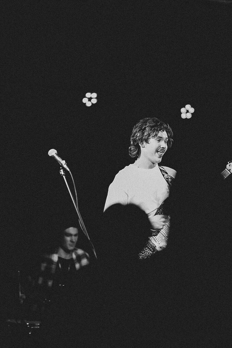 Black and white photograph of guitarist and singer of band through the crowd. Band is "Gone Out"