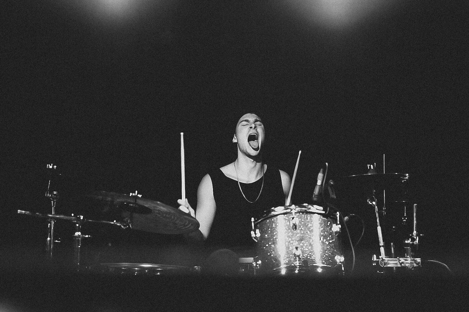 Black and white image of drummer with tongue out. Band is &quot;Gone Out&quot;