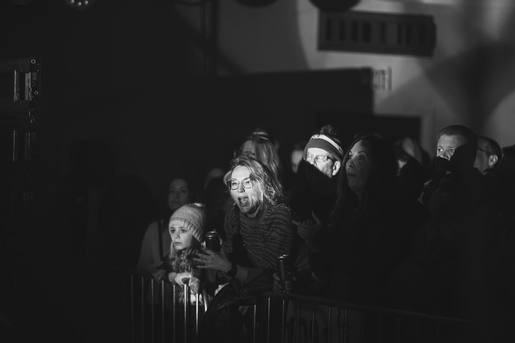Black and white photo of people in the crowd cheering.