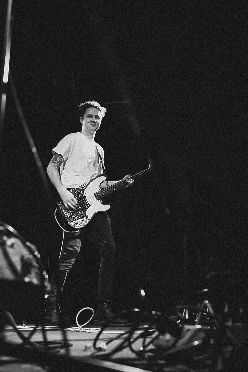 Black and white of bassist smiling on stage. Band is &quot;Gone Out&quot;