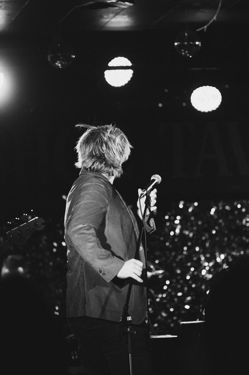 Black and white of lead vocalist dancing on stage. Band is "Silverstone Hills"