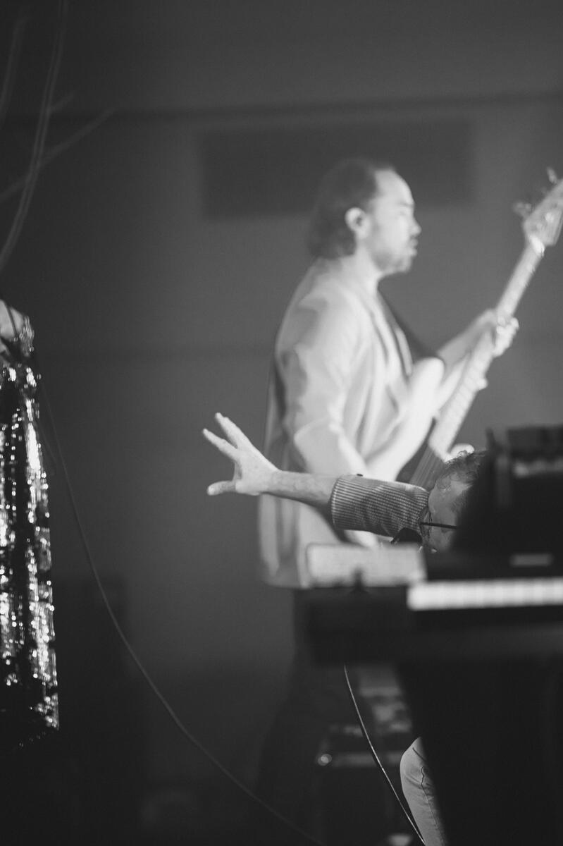 Black and white image of lead's hand stretched out and reaching towards other member. Band is "Stars"