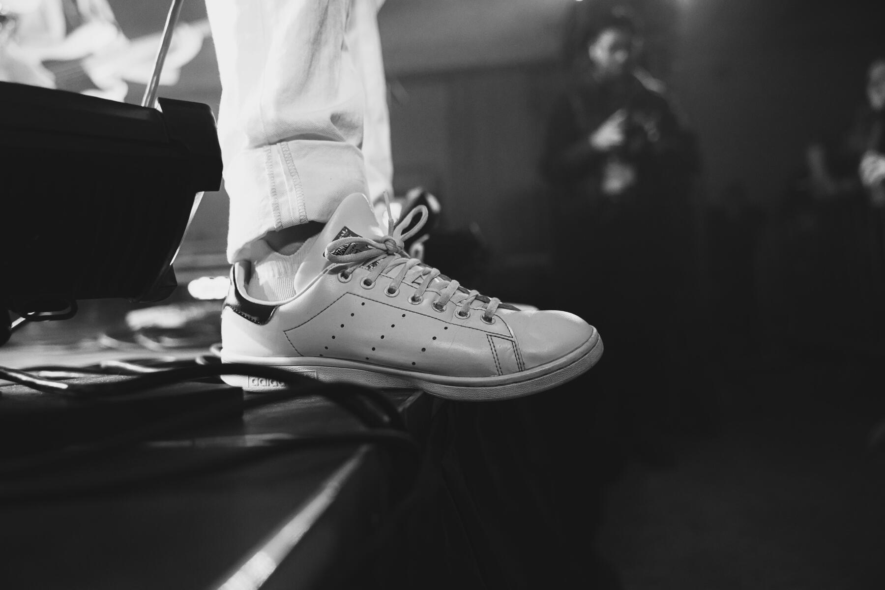 Black and white image of lead vocalist's shoe hanging off the edge of the stage. Band is "Stars"