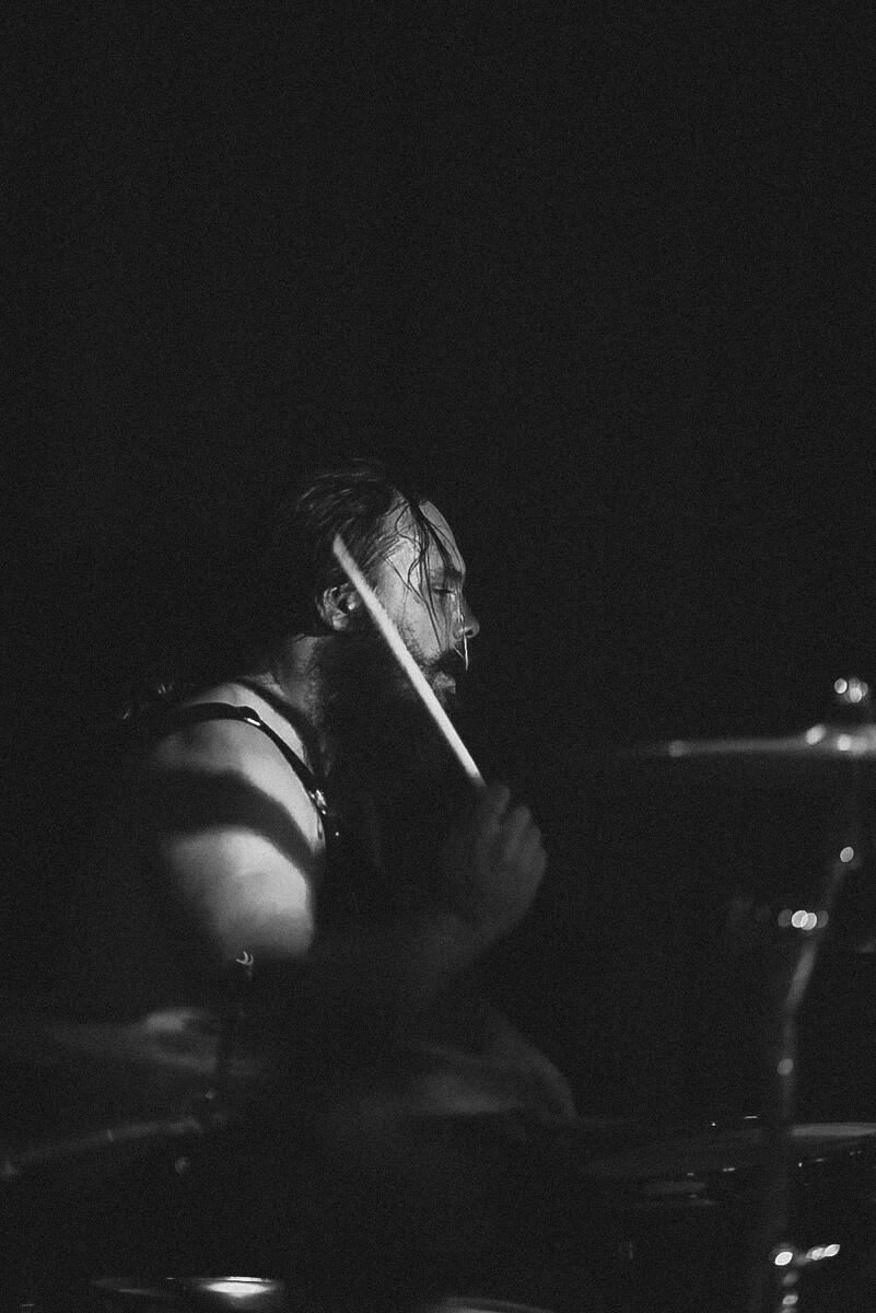 Black and white photo of drummer swinging drum stick. Band is "El Paladin"