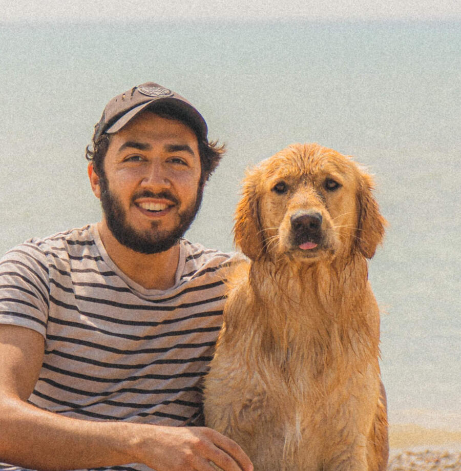 Image of concert photographer, Michael Tommasone, of Moshpit Memories. Photographer is hugging a golden retriever dog with tongue out. Blep.